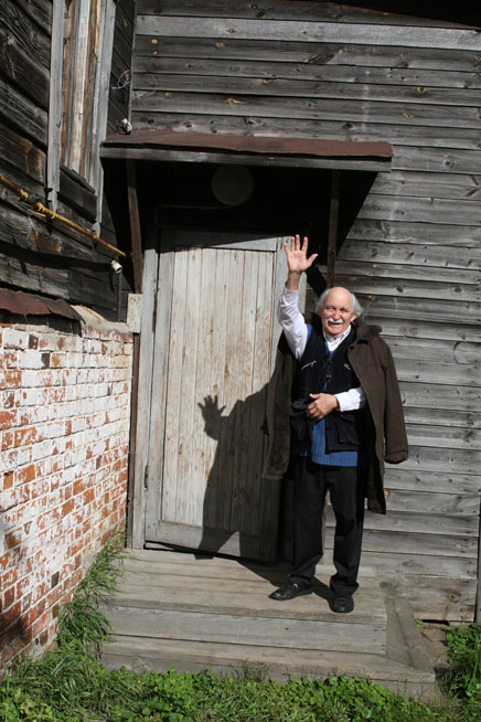 Victor Ivanov is greeting guests at the doorstep of his house in Isady village